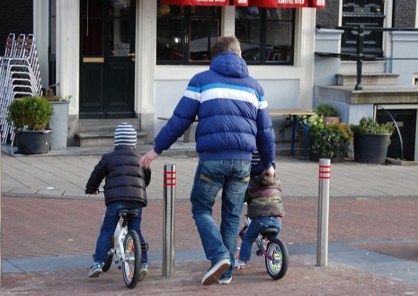 Father and sons on bikes by Joni