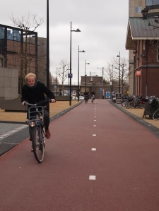 Eske cycling on a windy day in Amsterdam